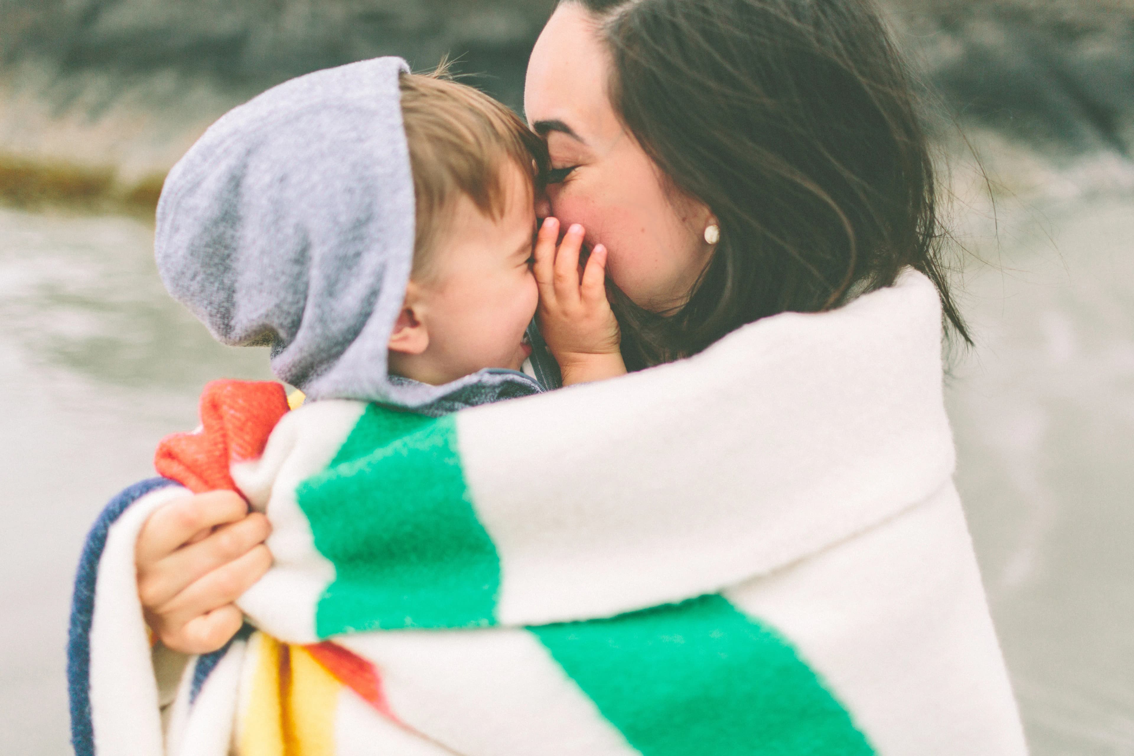 A women holding her baby whilst both wrapped in a towel